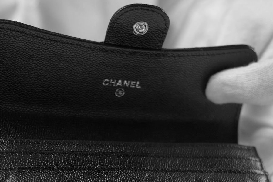 Interno di un portafoglio Chanel in pelle caviar nera con logo CHANEL